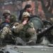 Anggota layanan pasukan Pro Rusia terlihat di atas kendaraan lapis baja selama konflik Ukraina-Rusia. Sumber foto : Reuters.