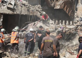 Petugas darurat bekerja di lokasi serangan Israel pada hari Jumat, sementara operasi pencarian dan penyelamatan terus berlangsung, di pinggiran selatan Beirut, Lebanon, 21 September 2024. REUTERS/Amr Abdallah Dalsh.