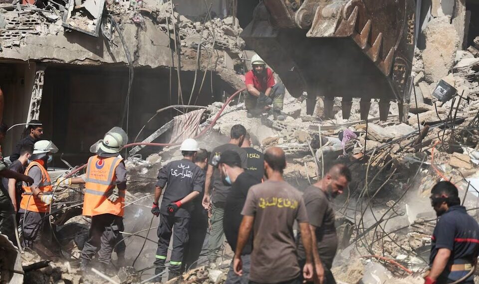 Petugas darurat bekerja di lokasi serangan Israel pada hari Jumat, sementara operasi pencarian dan penyelamatan terus berlangsung, di pinggiran selatan Beirut, Lebanon, 21 September 2024. REUTERS/Amr Abdallah Dalsh.