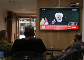Orang-orang menyaksikan Wakil Pemimpin Hezbollah, Sheikh Naim Qassem, menyampaikan pidato yang disiarkan di televisi, saat mereka duduk di sebuah kafe di Beirut, Lebanon, 15 Oktober 2024. REUTERS/Mohamed Azakir