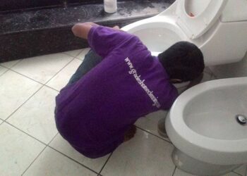 Petugas Jasa Bersih Rumah saat membersihkan kloset duduk salah satu pelanggan.