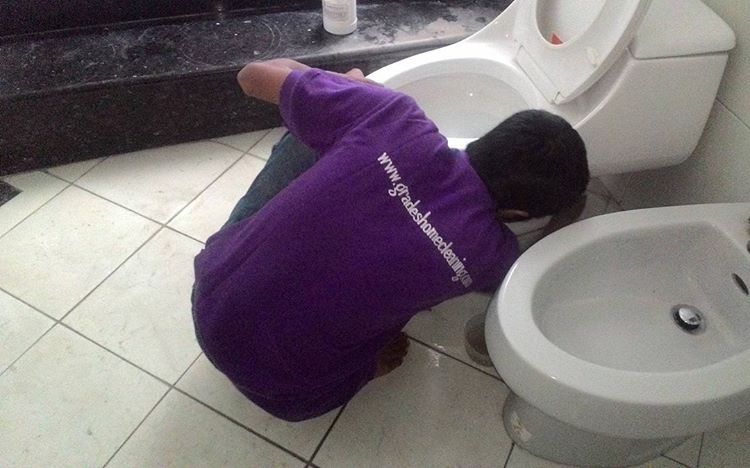 Petugas Jasa Bersih Rumah saat membersihkan kloset duduk salah satu pelanggan.