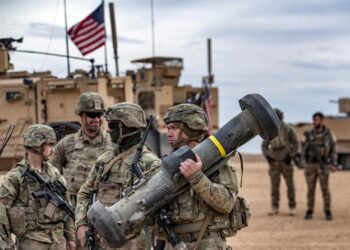 Seorang tentara Amerika membawa peluncur Javelin saat latihan militer antara Pasukan Demokratik Suriah (Syrian Democratic Forces) dan koalisi internasional pimpinan AS melawan kelompok Daesh, di wilayah pedesaan Deir Ezzor, timur laut Suriah, pada 7 Desember 2021. Sumber foto : AFP.