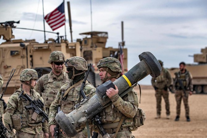 Seorang tentara Amerika membawa peluncur Javelin saat latihan militer antara Pasukan Demokratik Suriah (Syrian Democratic Forces) dan koalisi internasional pimpinan AS melawan kelompok Daesh, di wilayah pedesaan Deir Ezzor, timur laut Suriah, pada 7 Desember 2021. Sumber foto : AFP.