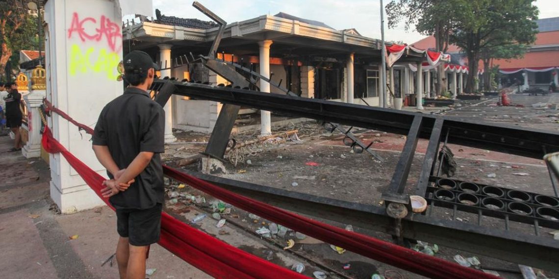 Warga saat melihat puing-puing Gedung Grahadi yang menjadi korban pembakaran oleh massa.