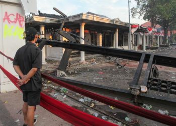 Warga saat melihat puing-puing Gedung Grahadi yang menjadi korban pembakaran oleh massa.