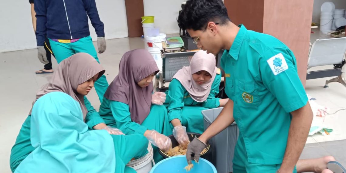 Keterangan foto: Ali Rayyan (kanan) bersama siswa melakukan inovasi olah sampah yang cepat, higienis, tanpa bau dan tanpa emisi bertajuk “KomProMi”